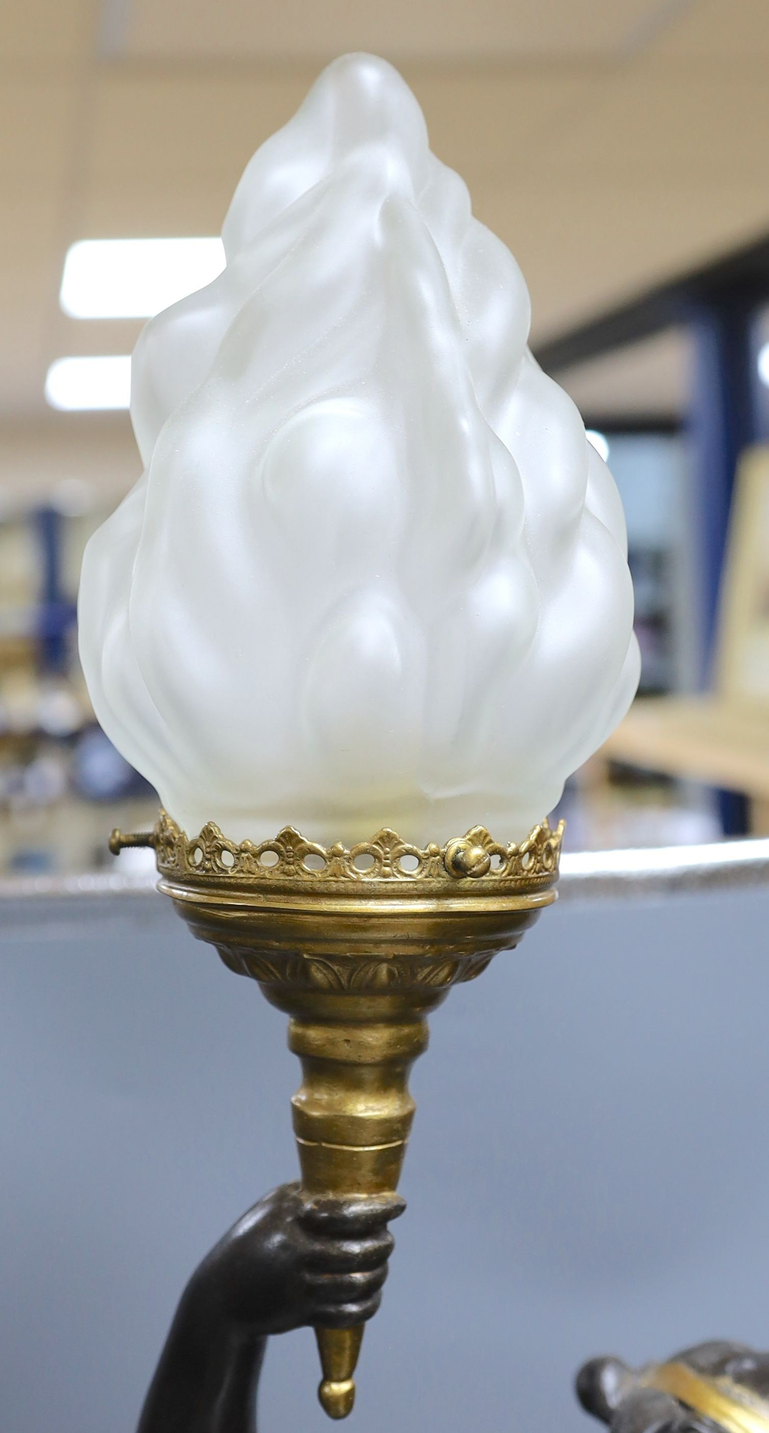 A gilt and brown patinated spelter putto lamp with flame glass shade, signed Moreau